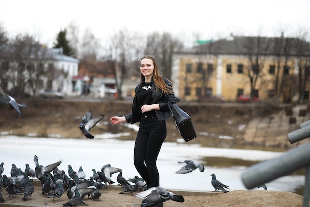 Girl on a walk in the park and a flock of pigeons