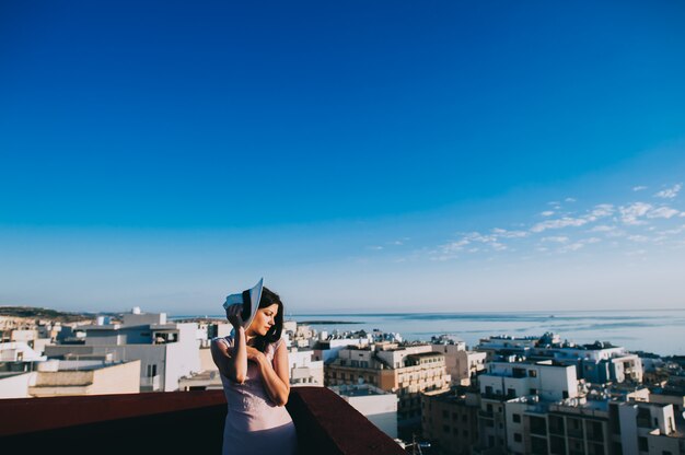 Foto ragazza cammina sui tetti della grande città