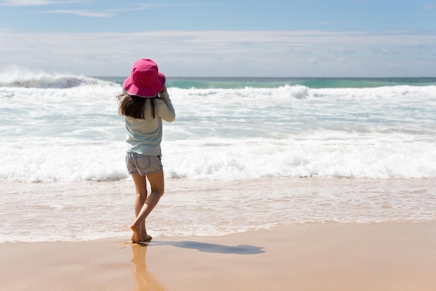 girl walking at beach against sky