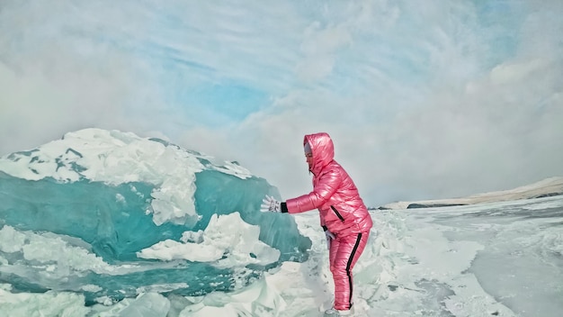 凍った湖の割れた氷の上を歩く少女バイカル湖の女の旅