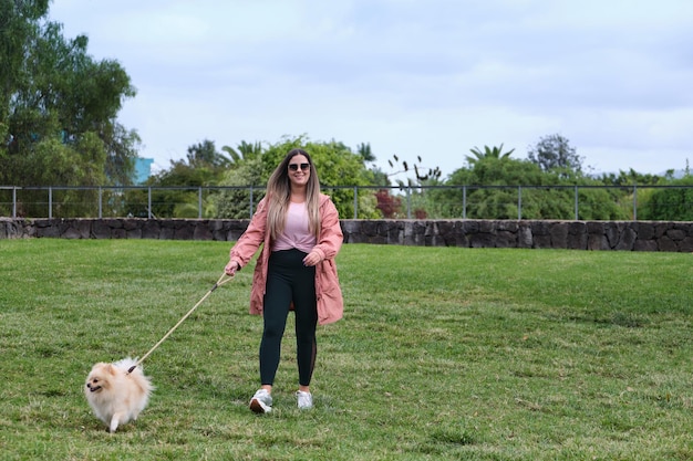 Photo girl walking her dog in a park pomeranian dog