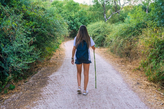 시골에서 하이킹 코스를 걷고 있는 소녀. 배낭 Hiking.Nomadic 라이프 스타일을 가진 여자