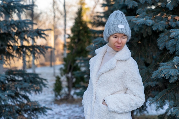 Фото Девушка гуляет в парке ранней весной на фоне елей