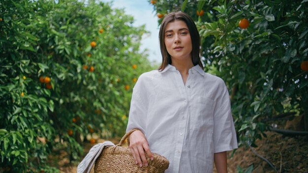 Girl walking orange garden closeup farmer woman strolling with basket at nature