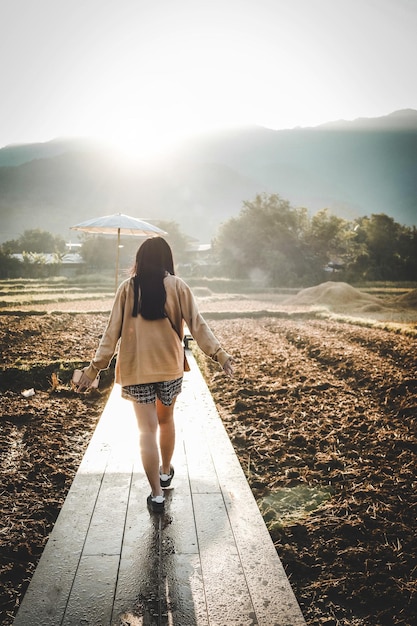 Girl walking on the path in the countryside field