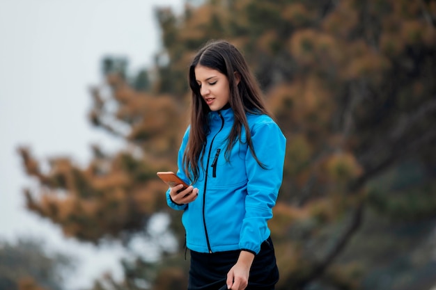 Photo girl walking and texting on the smart phone in the street