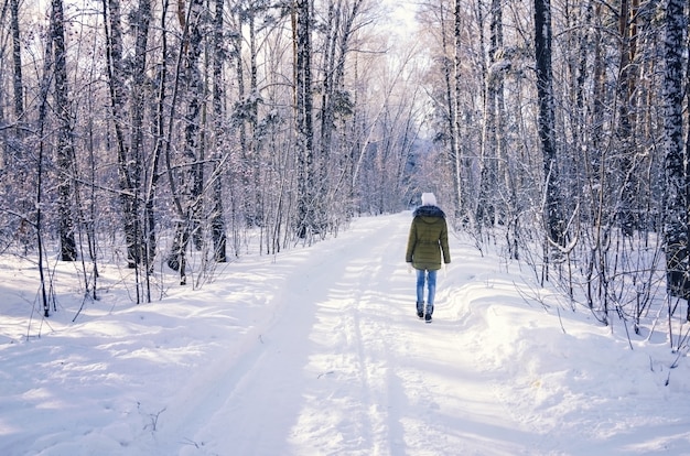 Girl walking in winter forest