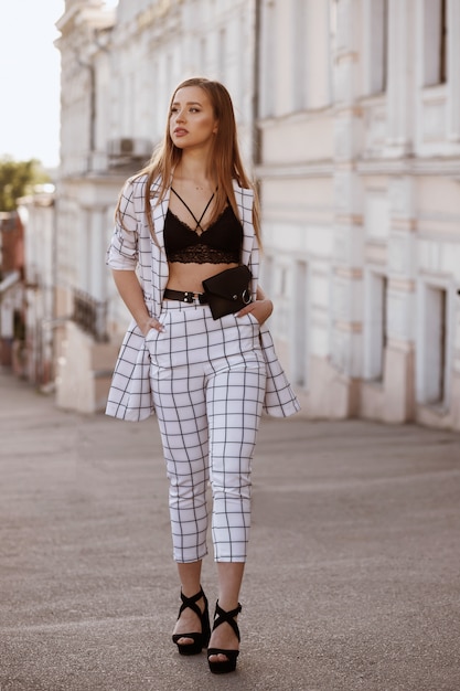 女孩在夏天穿着时尚的衣服在城市里散步