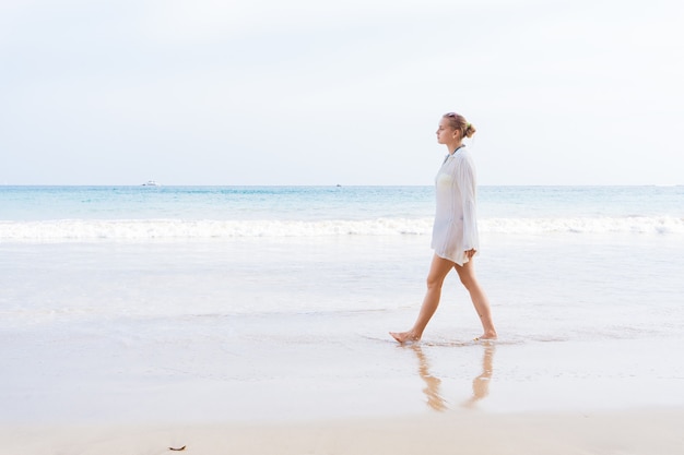 Girl walks the beach and in the water