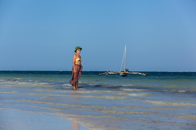 La ragazza cammina sulla spiaggia