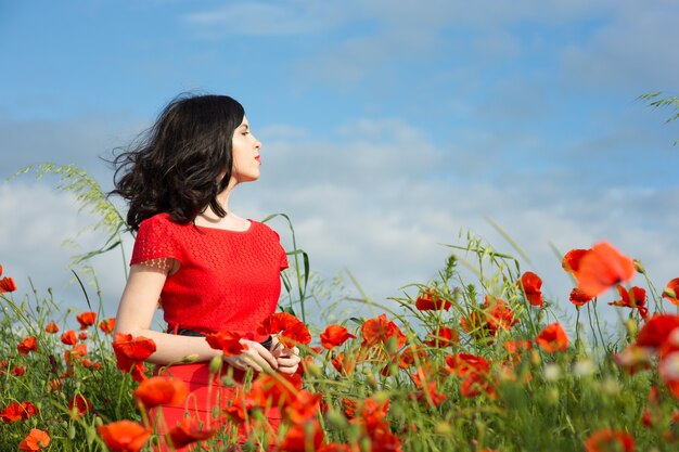 Girl walks in a field of poppies