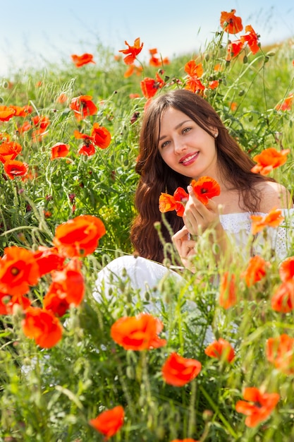 Girl walks in a field of poppies