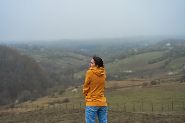 The girl walks in a meadow high in the mountains Spectacular views of the valley of the clouds