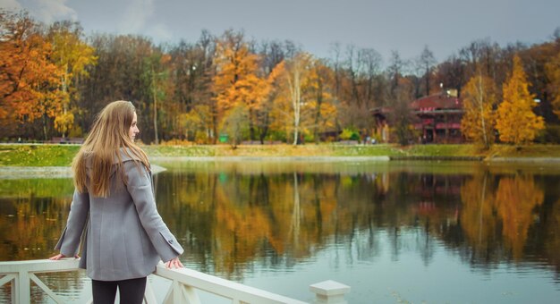 The girl walks in the park in the fall