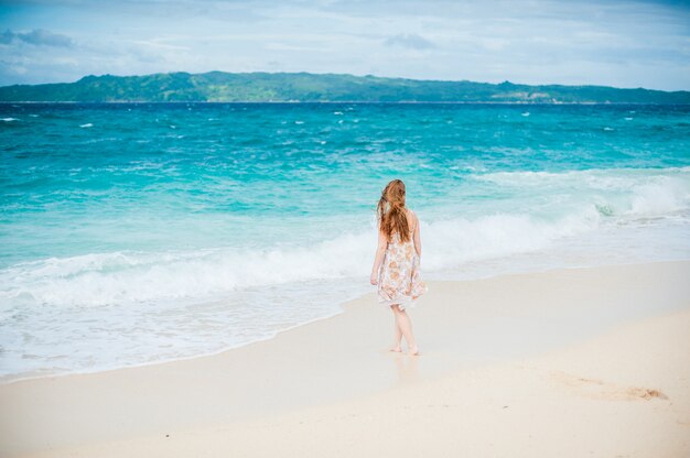 The girl walks on the water's edge on the Boracay