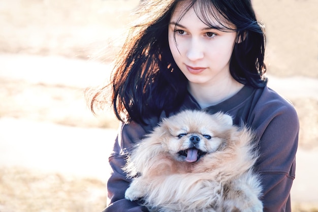 A girl walks with a dog in the park outdoor recreation with a pet a portrait with a small puppy