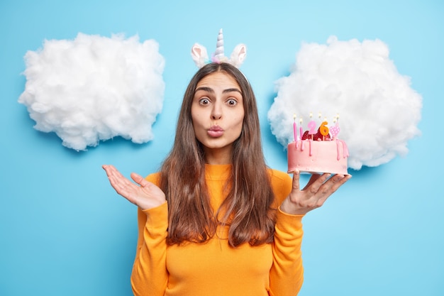 girl wants to kiss you says thank you for congratulation holds delicious birthday cake dressed in casual clothes poses on blue 