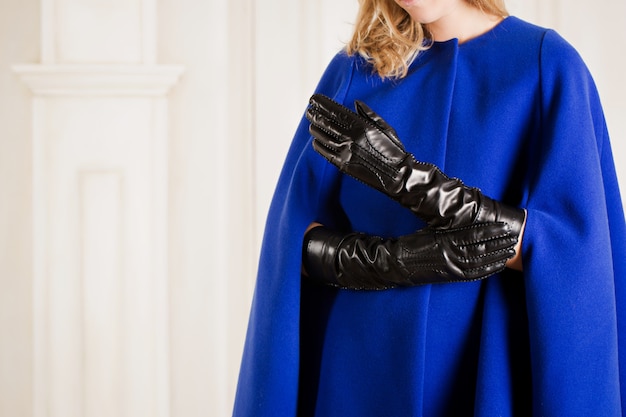 Girl in a warm blue cape and long leather gloves