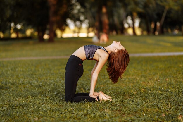 Ragazza in fase di riscaldamento e meditazione nel parco