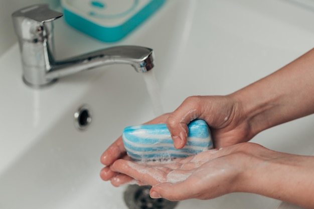 Photo the girl washes her hands to avoid infection with the virus covid