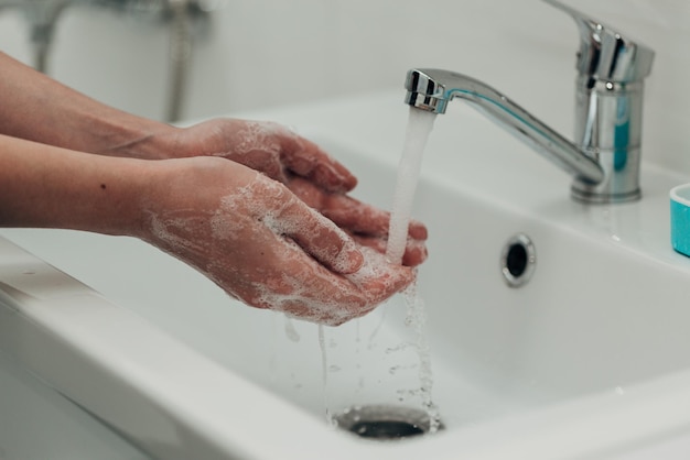 The girl washes her hands to avoid infection with the virus covid