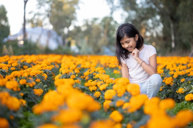 Girl watching and smiling at  cempasuchil flowers