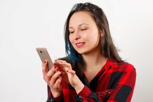 Girl waving on the phone while during a video call isolated on white wall