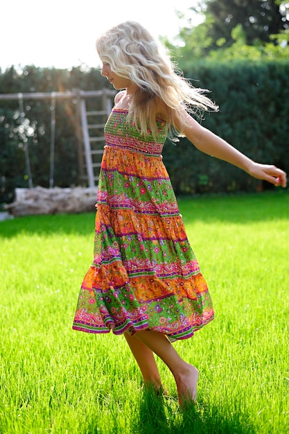 Girl wearing a dress playing in garden