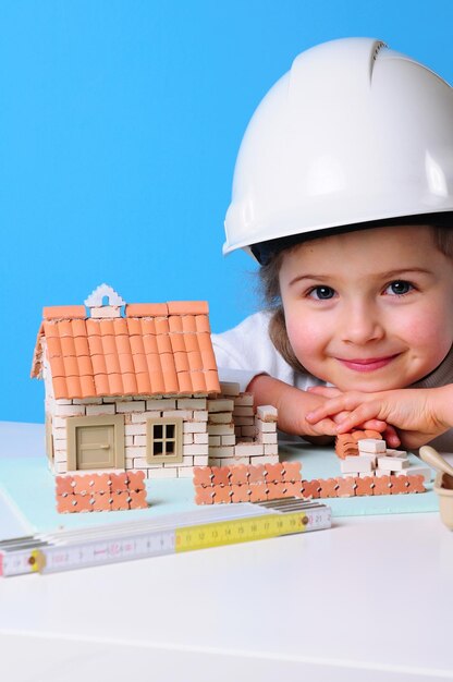 Photo a girl wearing a hard hat is wearing a hard hat and a hard hat that says  a house