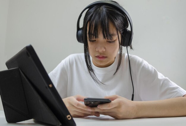 Girl wearing headphones studying online with computer laptop and listen to relaxing music or play internet social media at home