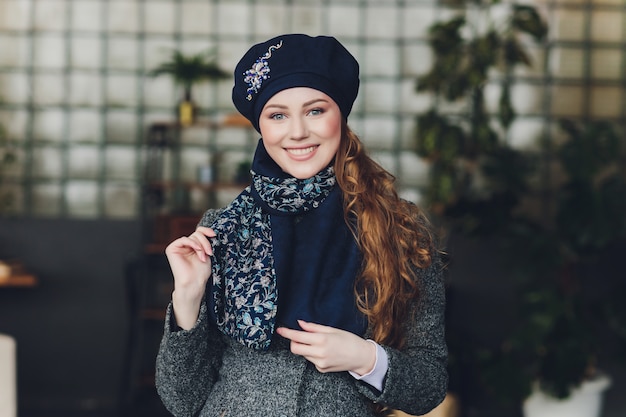 Девушка в вязаной теплой шапке, пальто и шарфе