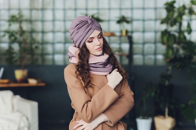 Девушка в вязаной теплой шапке, пальто и шарфе