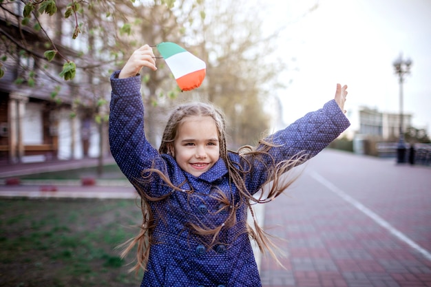 Girl wearing off the respirator medical mask in national Italy colors