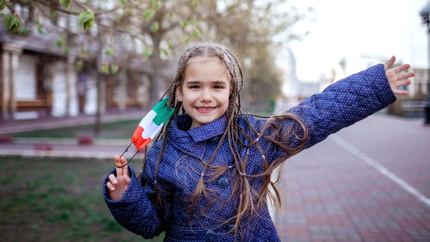 Ragazza che porta via la maschera medica del respiratore nei colori nazionali dell'italia