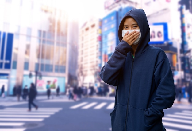 Maschera di protezione da portare della ragazza contro coronavirus nella città