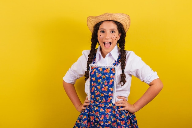 Girl wearing typical clothes for Festa Junina hands on hips smiling and happy For the Festival do Arraia