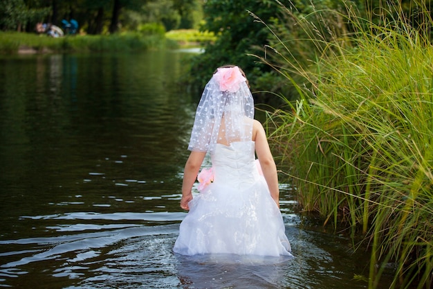 Girl in wedding dress in summer lake. High quality photo