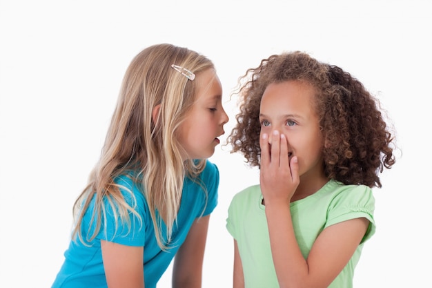 Photo girl whispering a secret to her friend