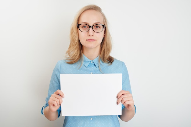 Girl on a white background holding a sign in hand closeup