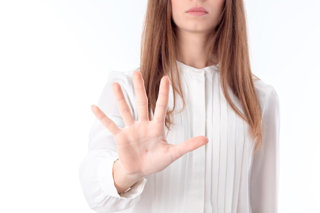 Девушка в белой блузке протянула руку вперед и показывает руку с растопыренными пальцами крупным планом