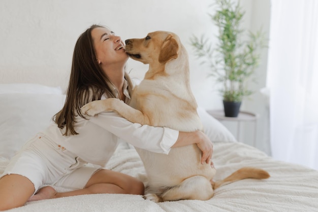 家で遊ぶ犬のラブラドールと白い服の女の子