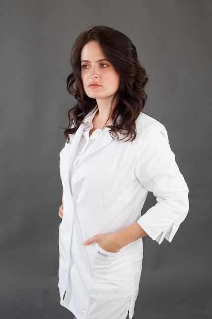 Girl in a white coat on a dark background