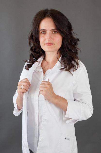 Girl in a white coat on a dark background