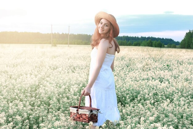 Girl in white dress in field of yellow flowers blossoming