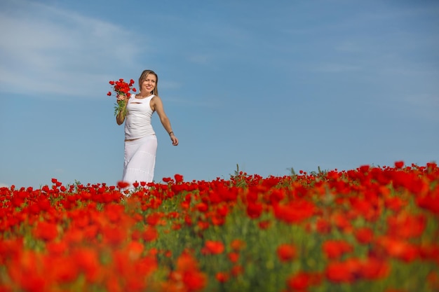 Girl in a white dress in the poppy field