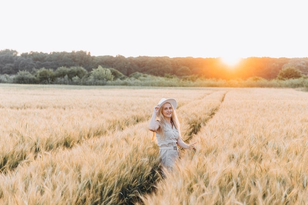 Girl in a white dress and a white hat in a wheat field