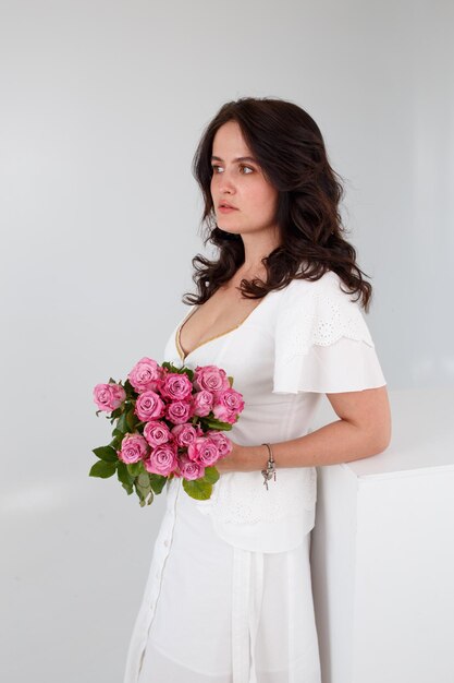 Girl in a white dress with a bouquet of flowers