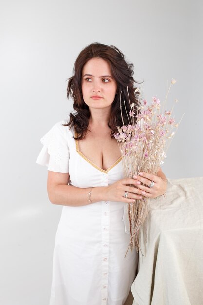 Girl in a white dress with a bouquet of flowers