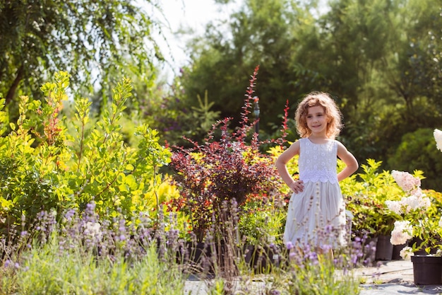 Photo girl in white dresses posing outdoors at flowers market lavender and hydrangea flowers