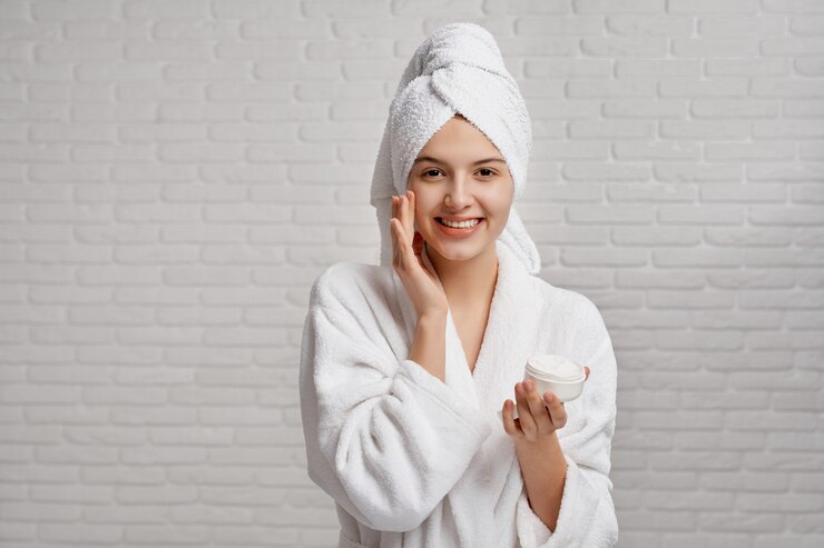 Photo girl in white dressing gown and towel caring about skin